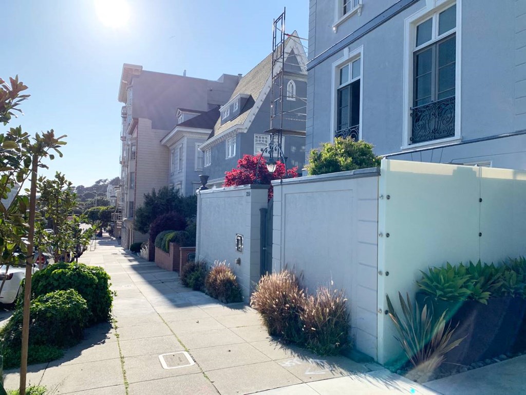 a city street with houses and a fence