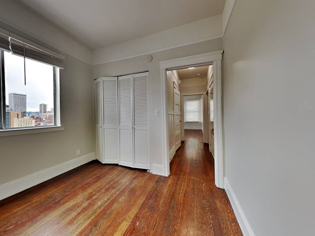 a living room with a large window and wooden floors