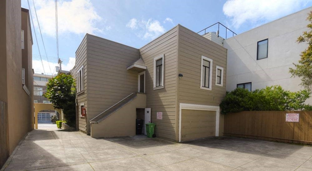 the side of a house with a parking lot