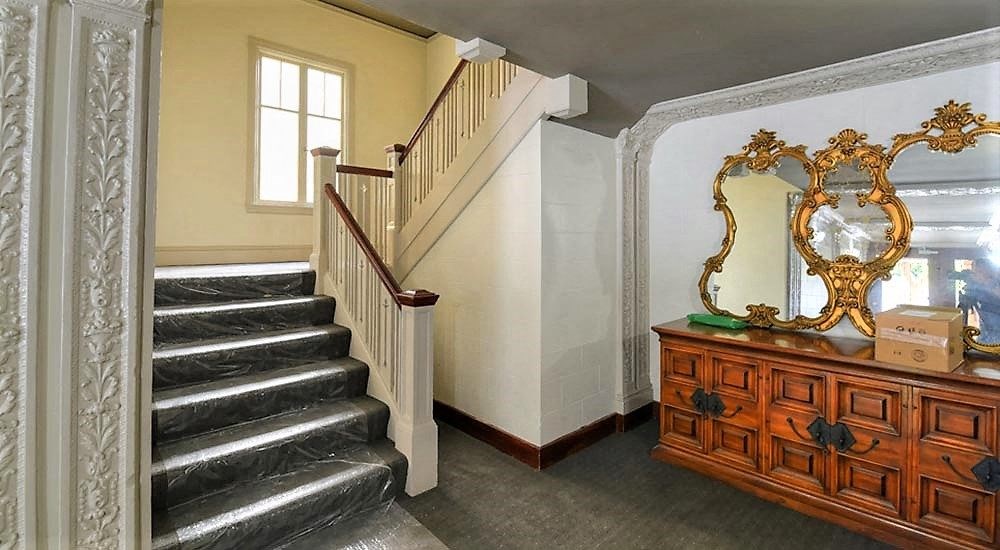 a staircase in a room with a dresser and a mirror