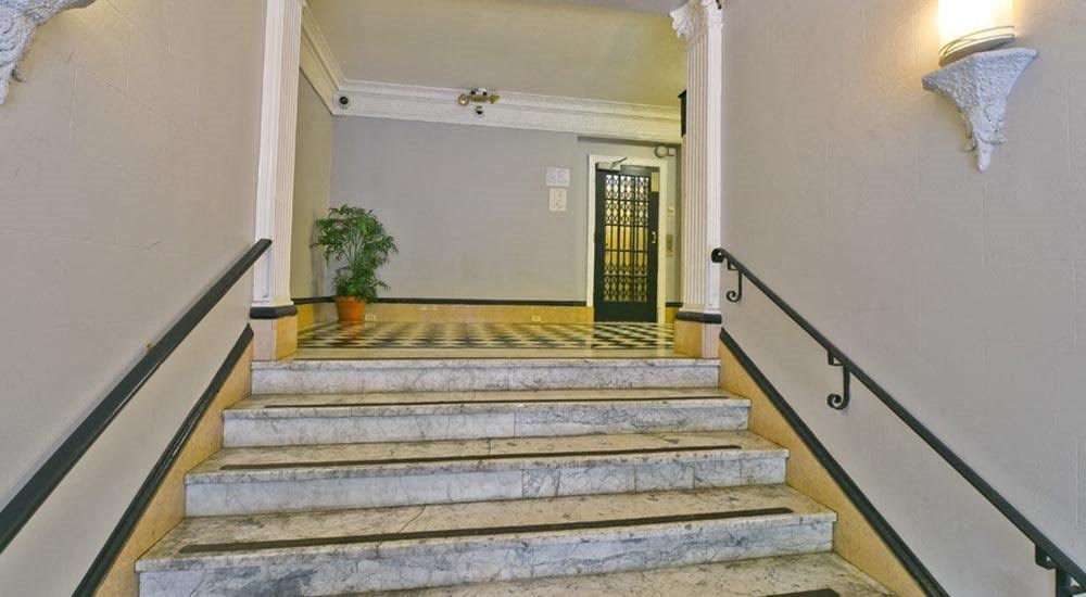a set of stairs leading to a lobby with a door