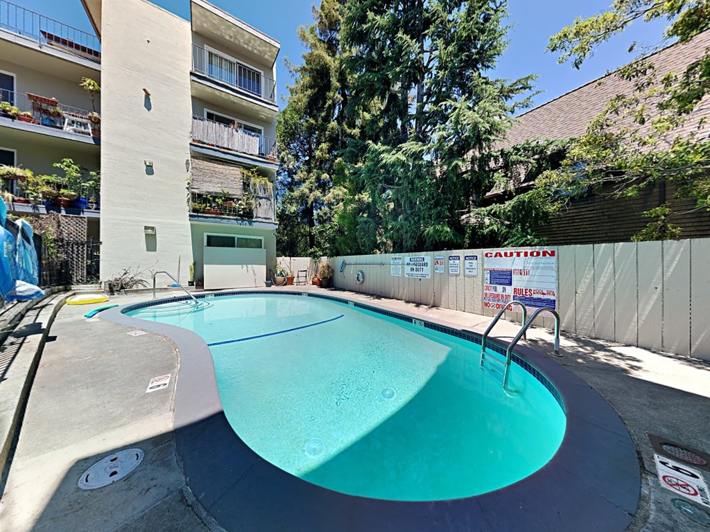 a swimming pool with an apartment building in the background