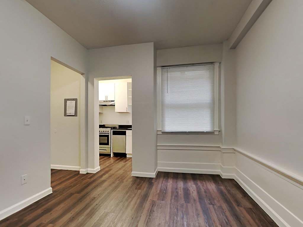 a living room and kitchen with wood floors and a window
