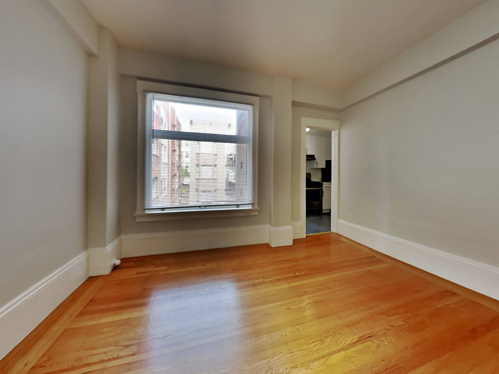 a living room with a large window and wooden floors