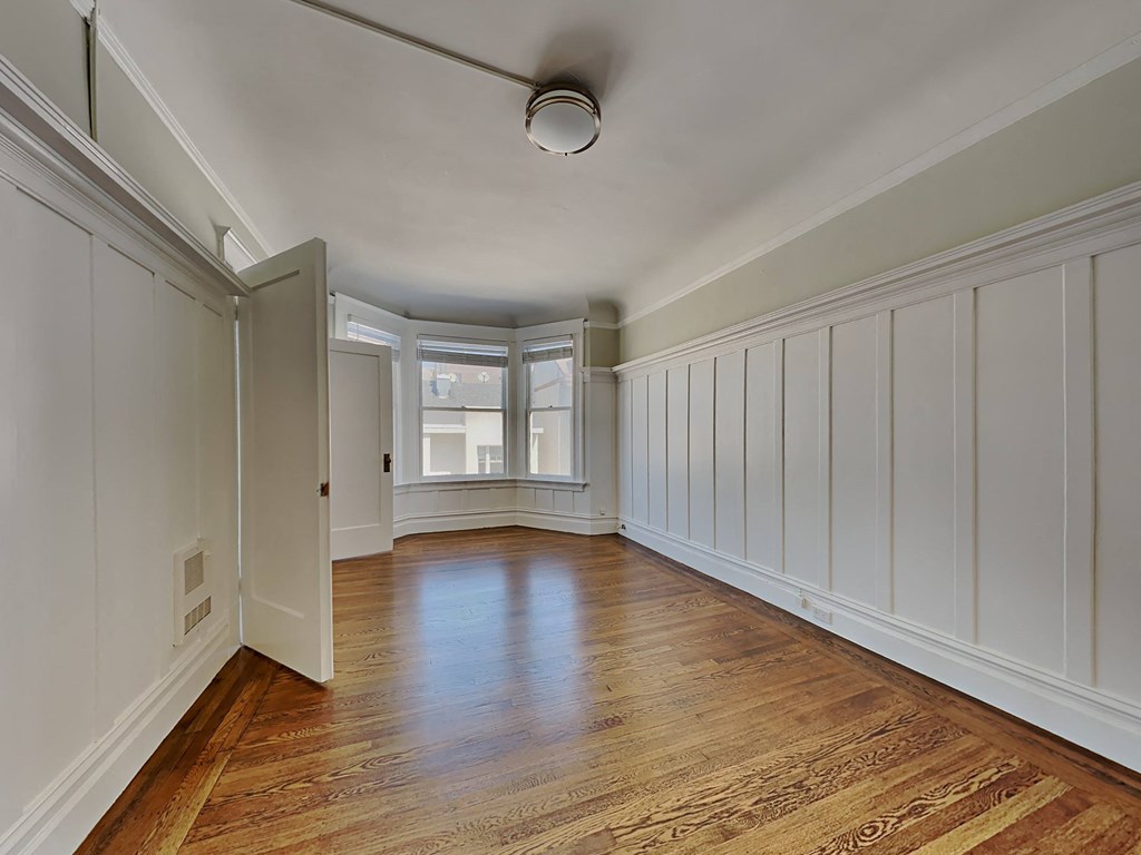 a living room with white walls and wood floors