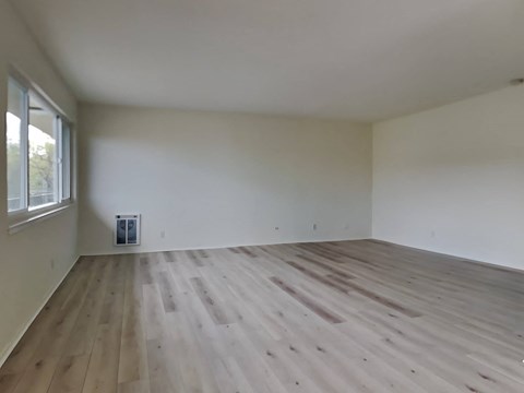 an empty room with white walls and wooden floors