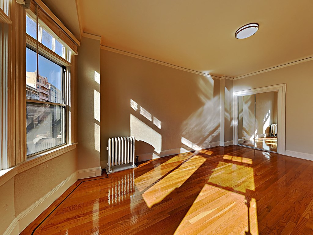 a living room with a hard wood floor and a large window