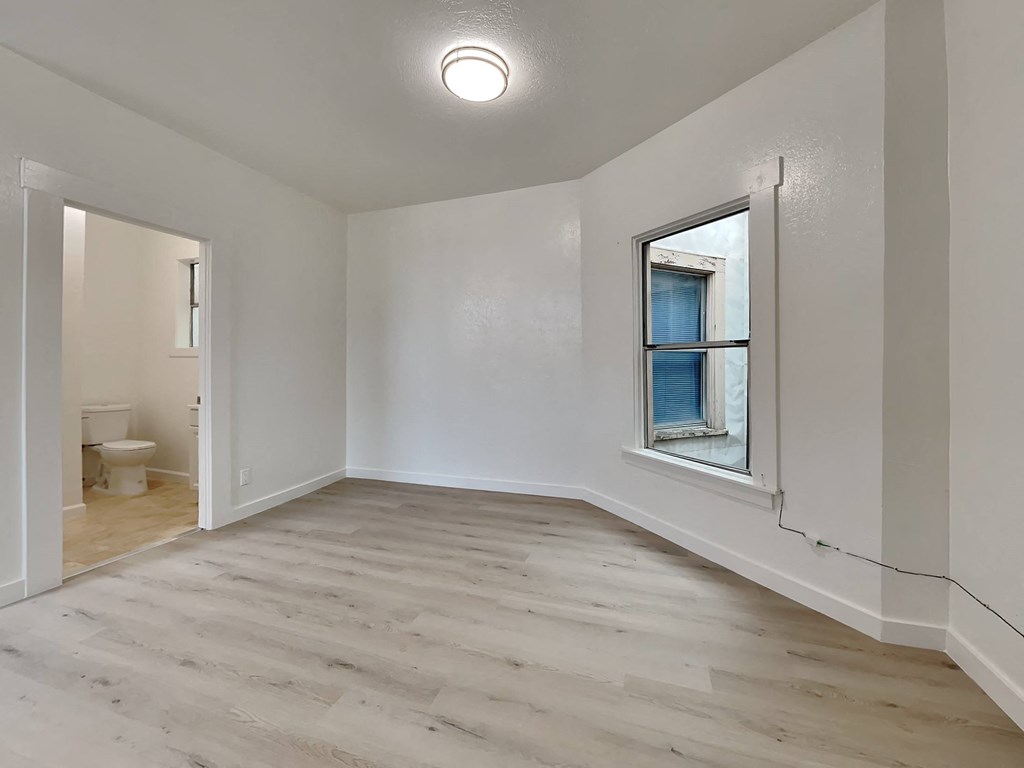 a living room with white walls and a window