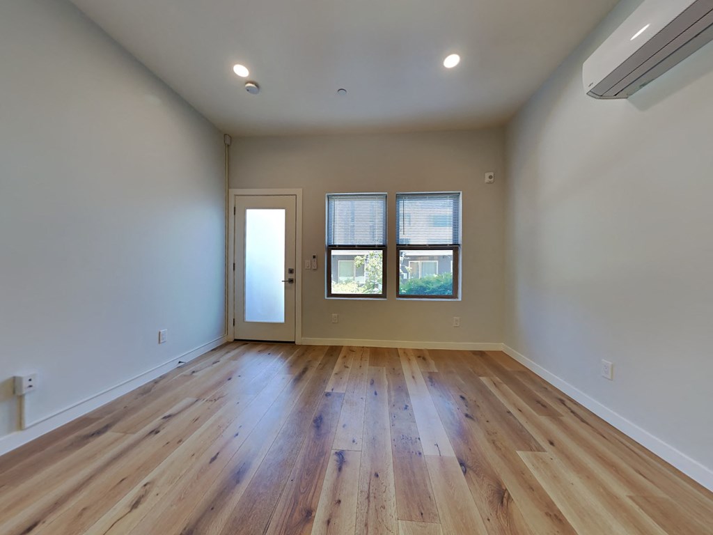 an empty living room with hardwood floors and a window
