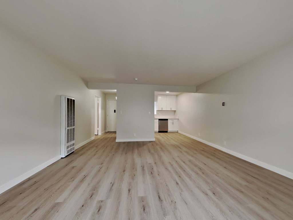 a living room with wood floors and white walls