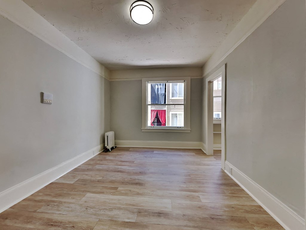 a living room with a window and a hard wood floor