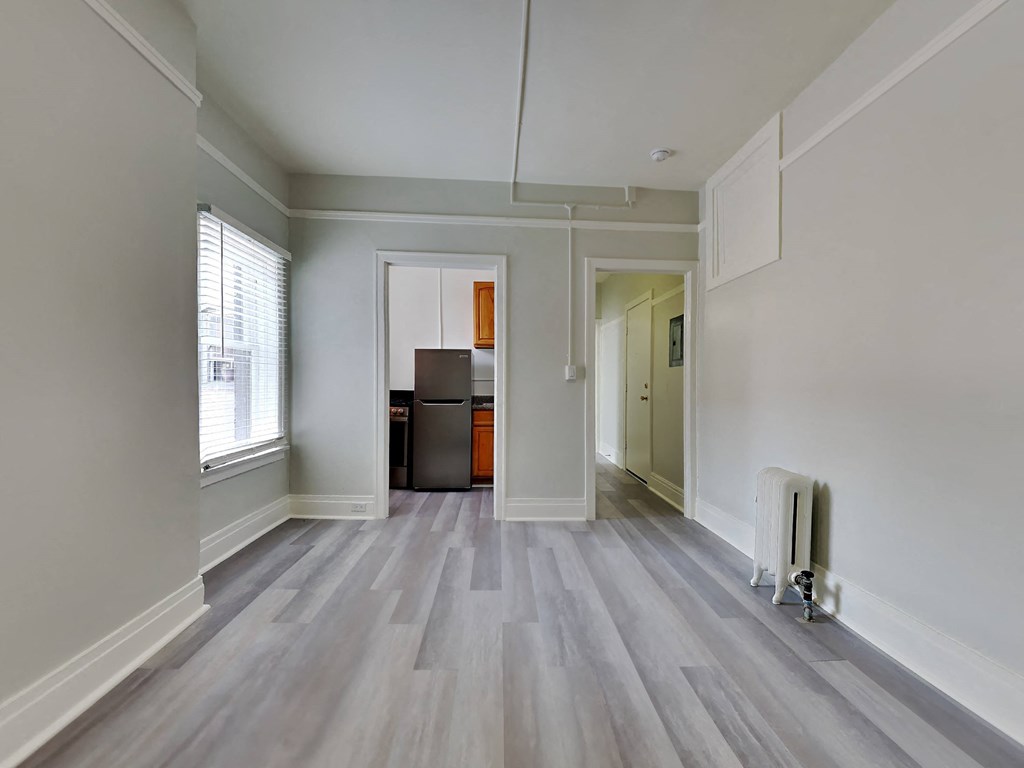 an empty living room with white walls and wood flooring