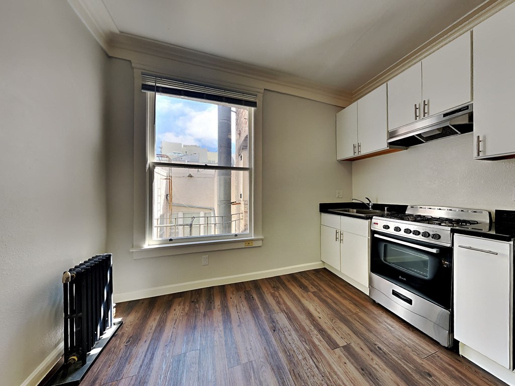an empty kitchen with a stove and a window
