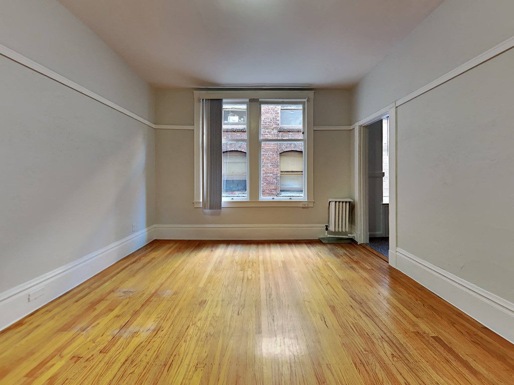 a living room with wood floors and a window