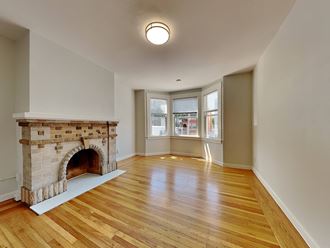 a living room with a fireplace and a hard wood floor