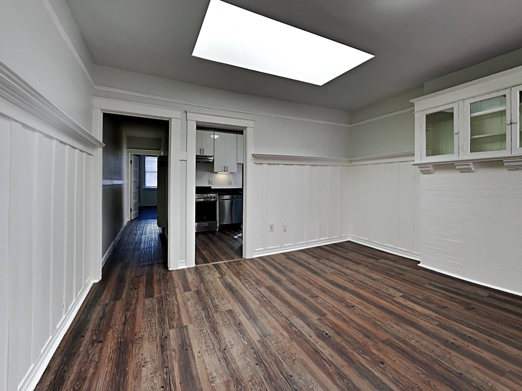 a kitchen and living room with wood flooring and a window