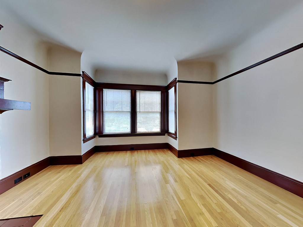 a empty room with wood floors and windows