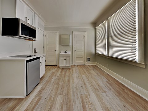 a kitchen with a stove and a microwave and a window