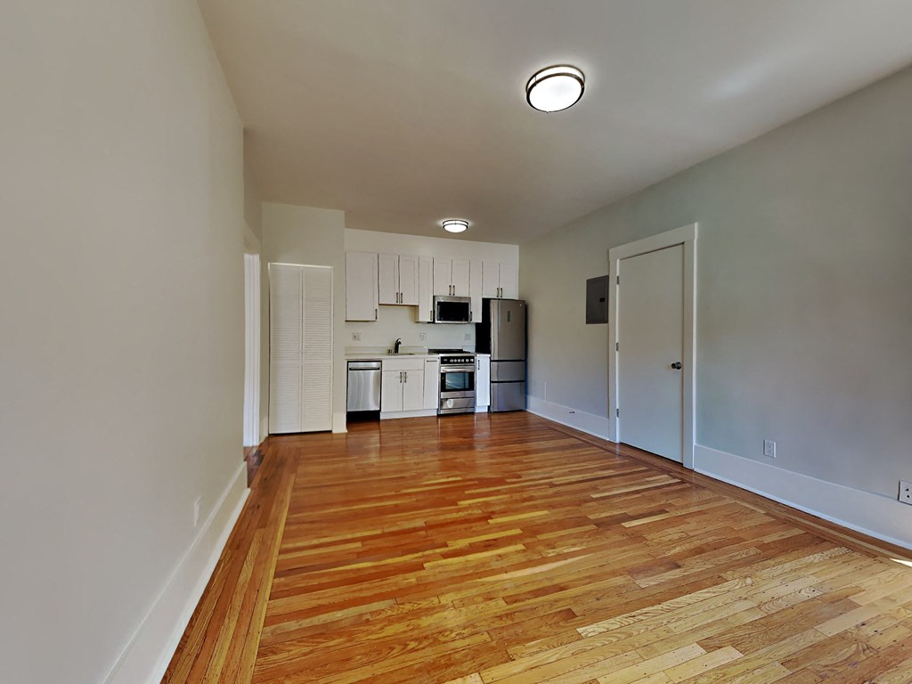 a living room with a hard wood floor and a kitchen