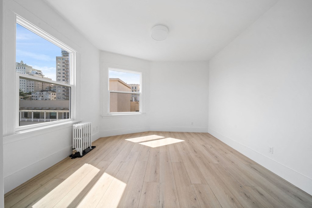 a living room with a large window and wooden floors