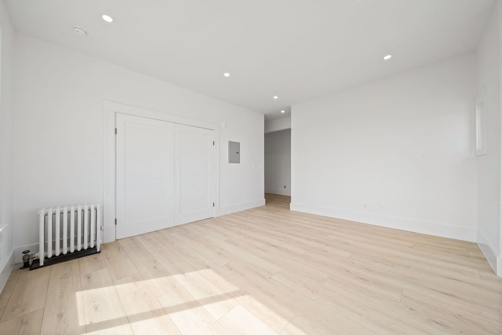 a living room with white walls and wood floors