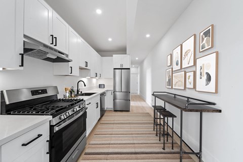 a kitchen with white cabinets and black appliances