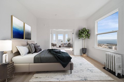 a bedroom with a bed and two large windows