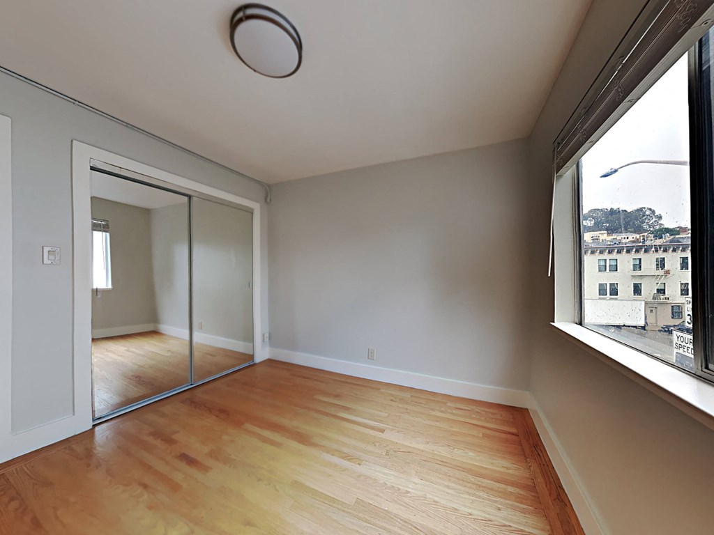 a living room with a large window and wooden floors