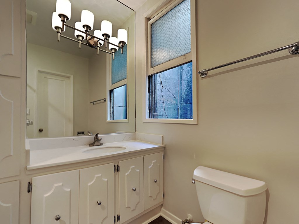 a bathroom with a sink toilet and a window