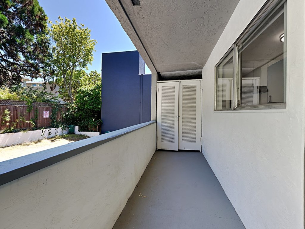 a long balcony with a door and a window on the side