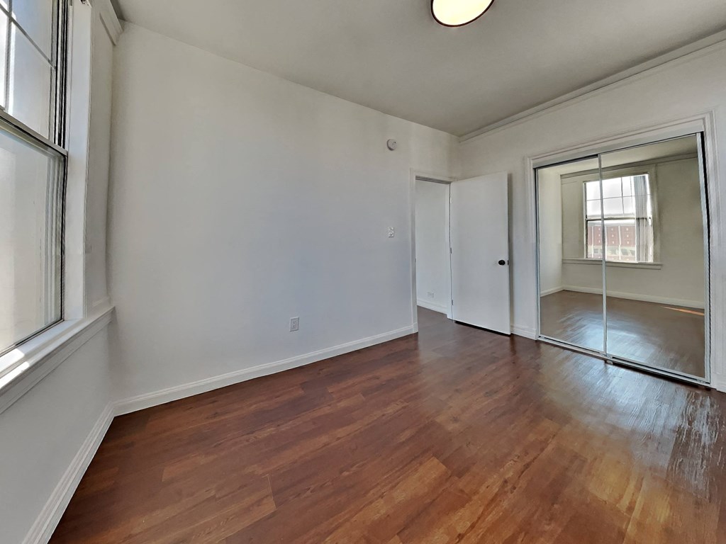 an empty living room with wood floors and a sliding glass door