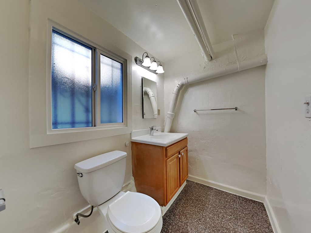 a bathroom with a toilet and a sink and a window
