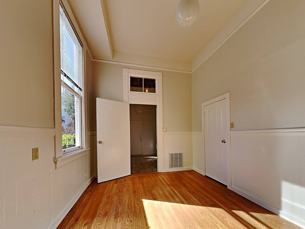 an empty living room with a door to a closet