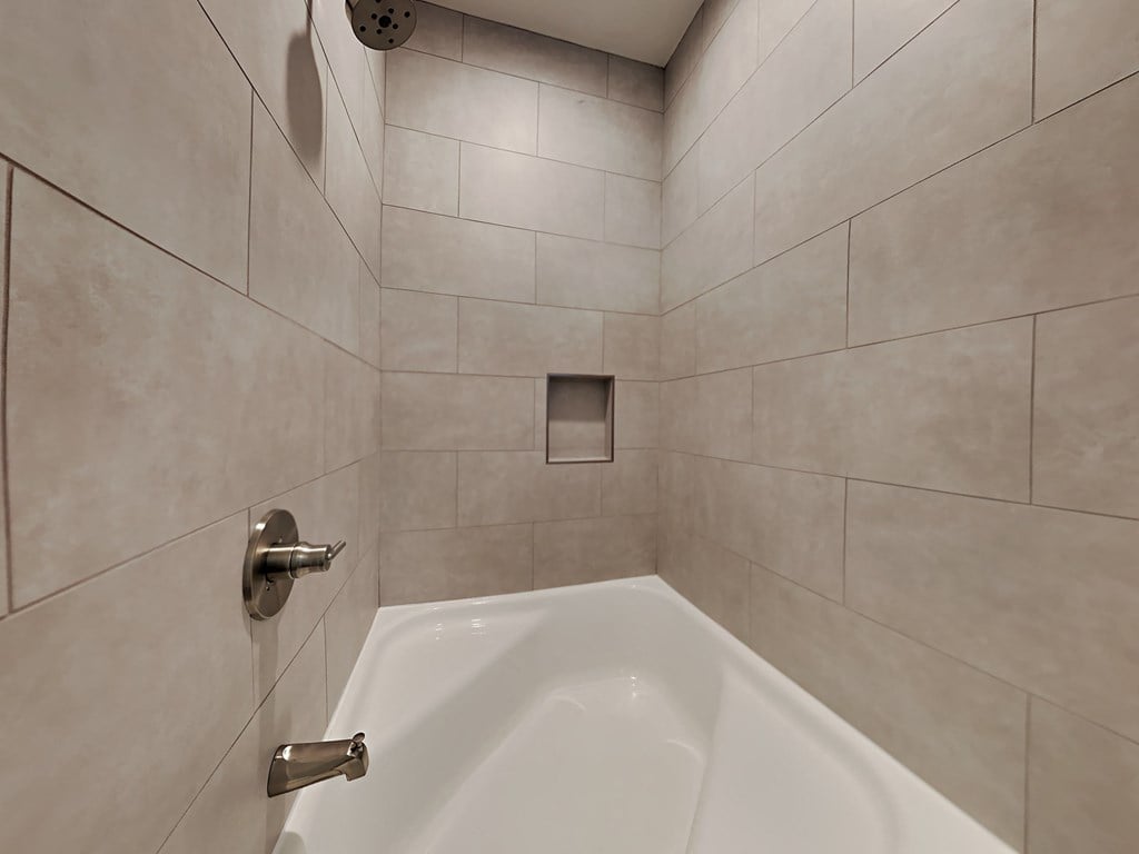 a bathroom with a tub and a shower in it