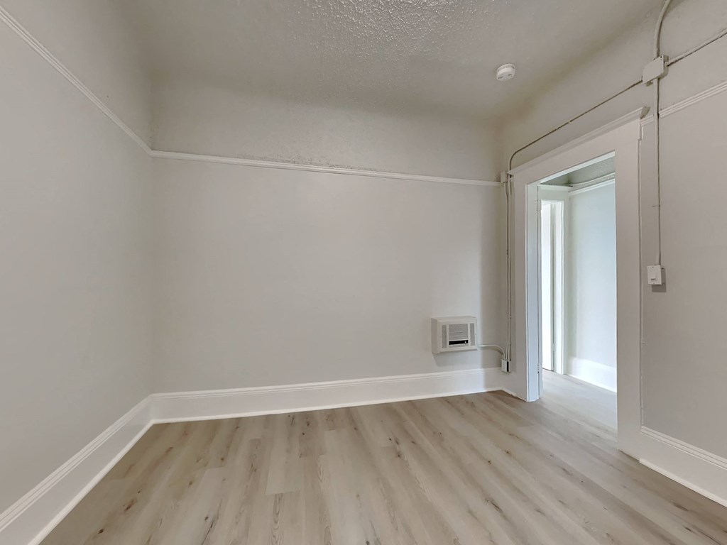 a living room with white walls and wooden floors