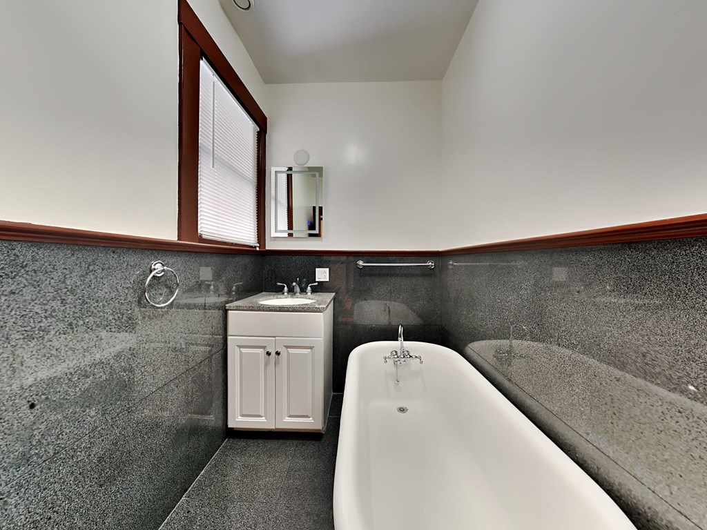 a bathroom with a tub and a sink and a window