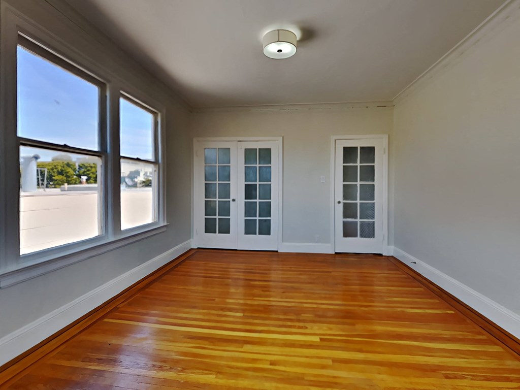an empty living room with wood floors and windows