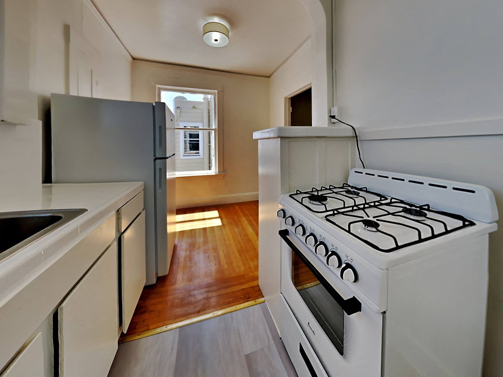 an empty kitchen with a stove and a refrigerator