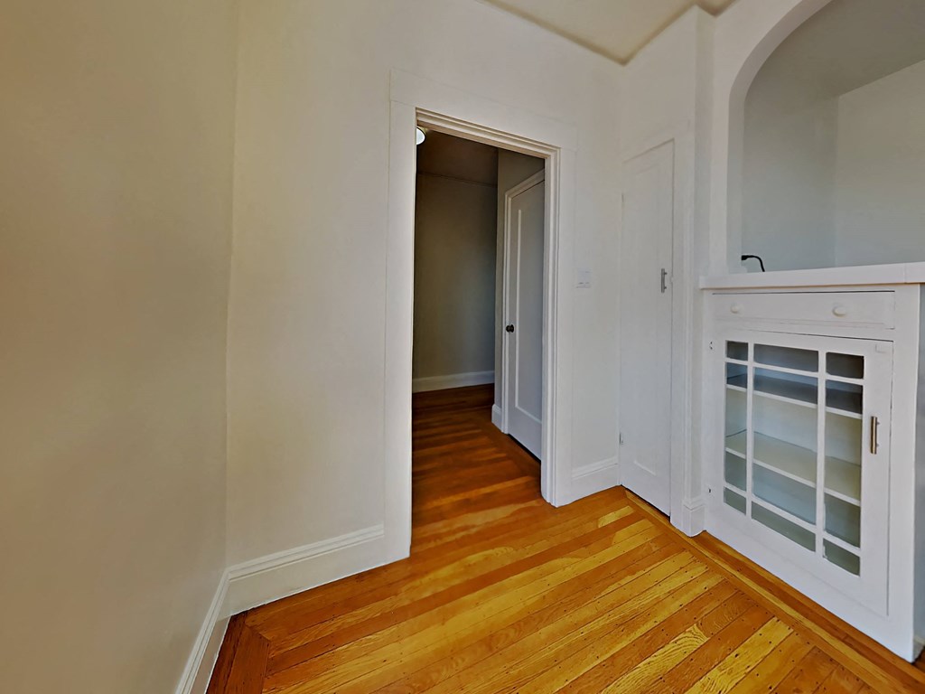 a bedroom with a door to a hallway and a door into a closet