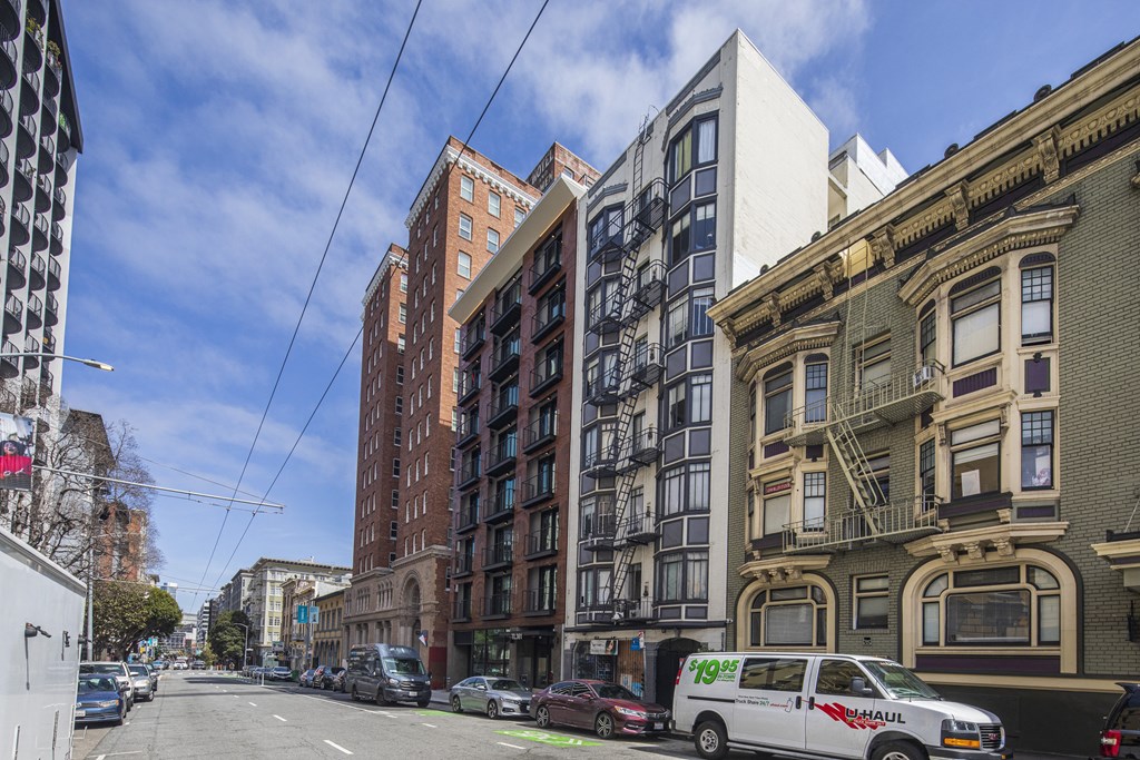 a view of a city street with buildings and a van