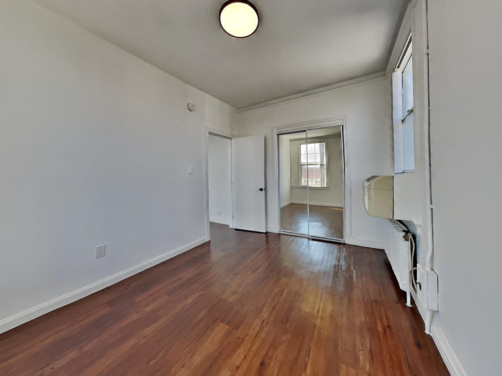 an empty living room with hardwood floors and white walls