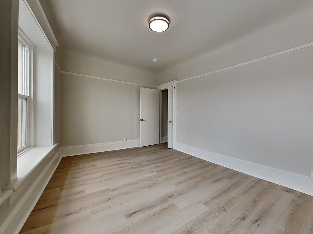 a living room with wood floors and white walls
