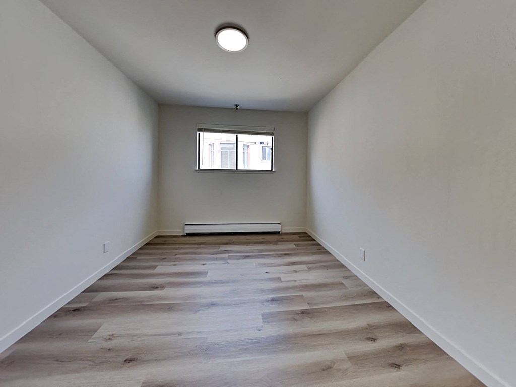 a empty room with wood floors and a window