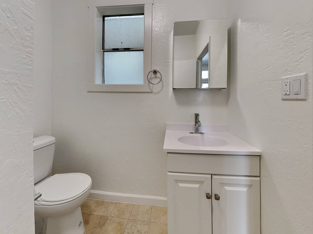 a bathroom with a sink toilet and a mirror