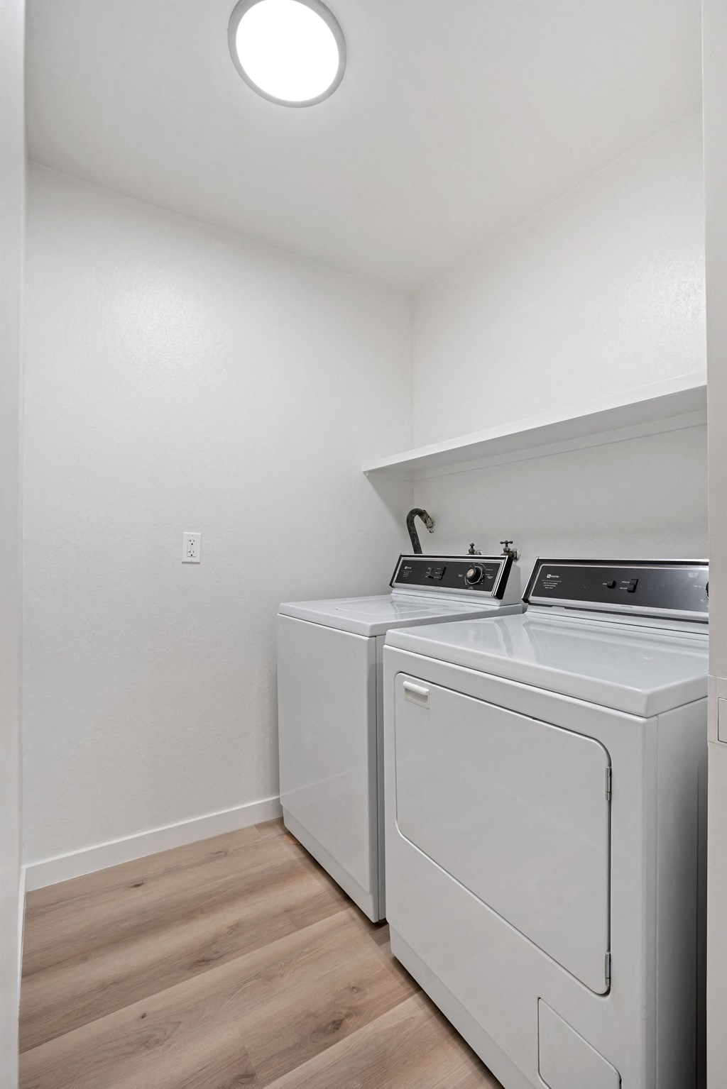 an empty laundry room with a washer and dryer and a white washer