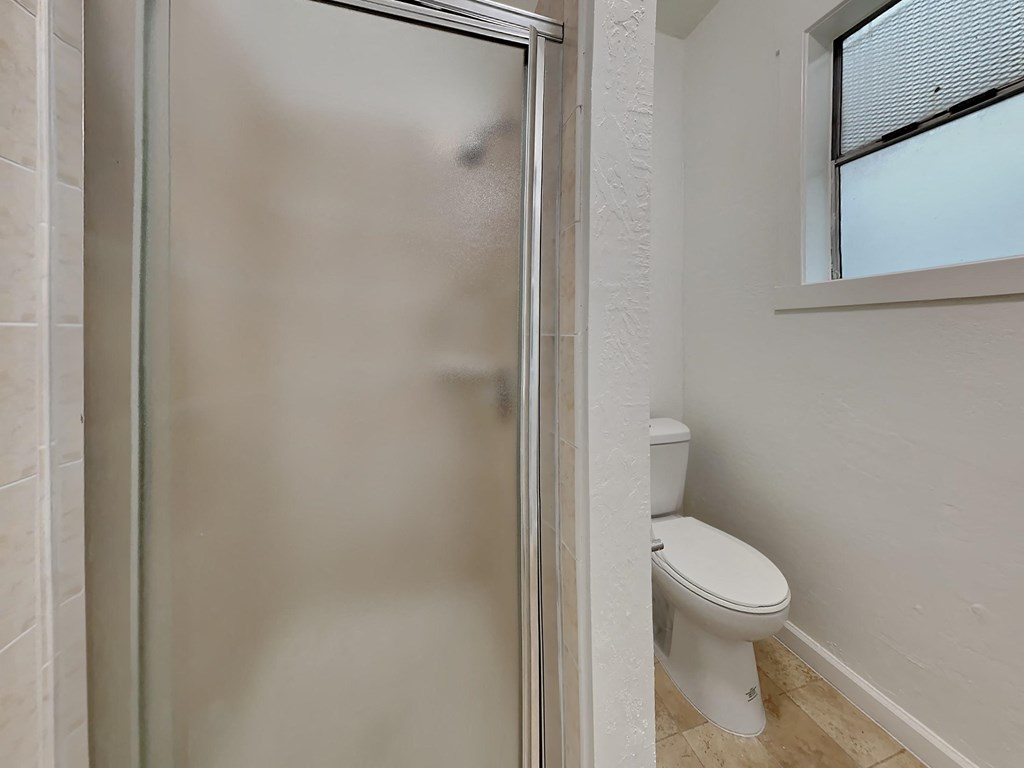 a bathroom with a toilet and a shower