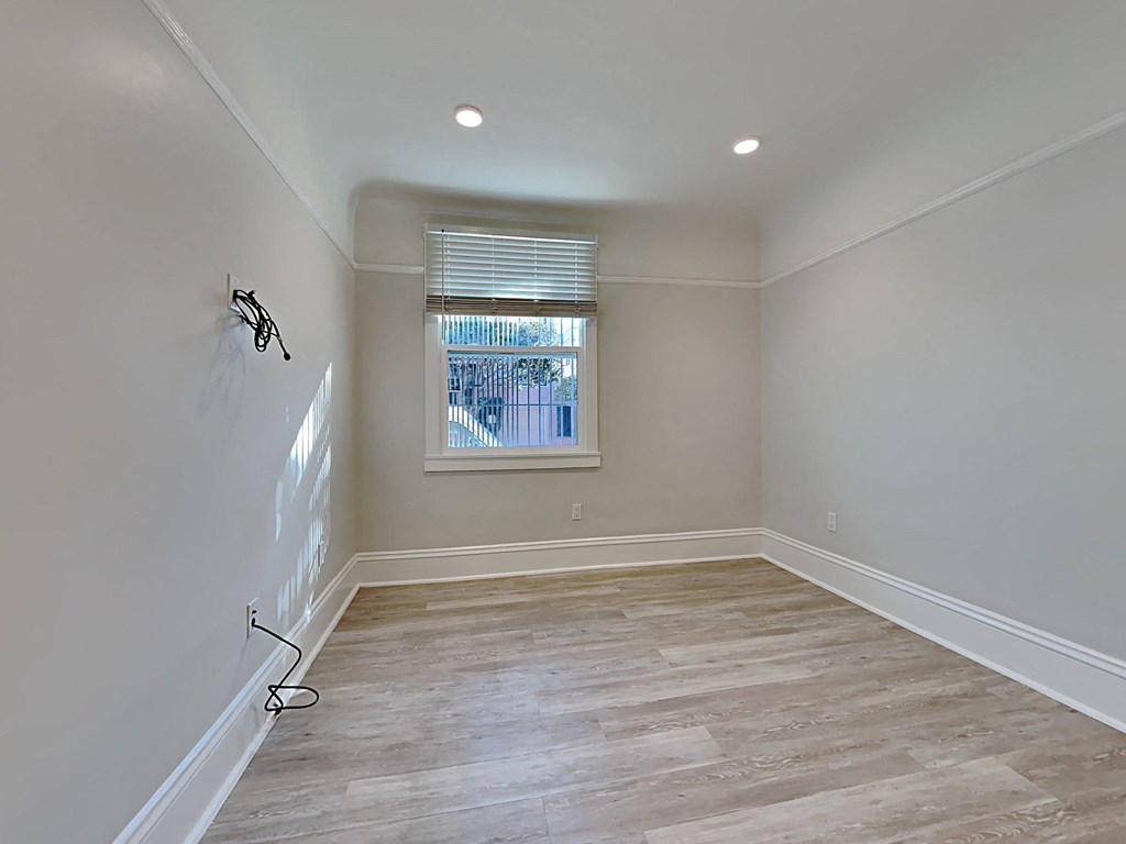 an empty room with a window and white walls