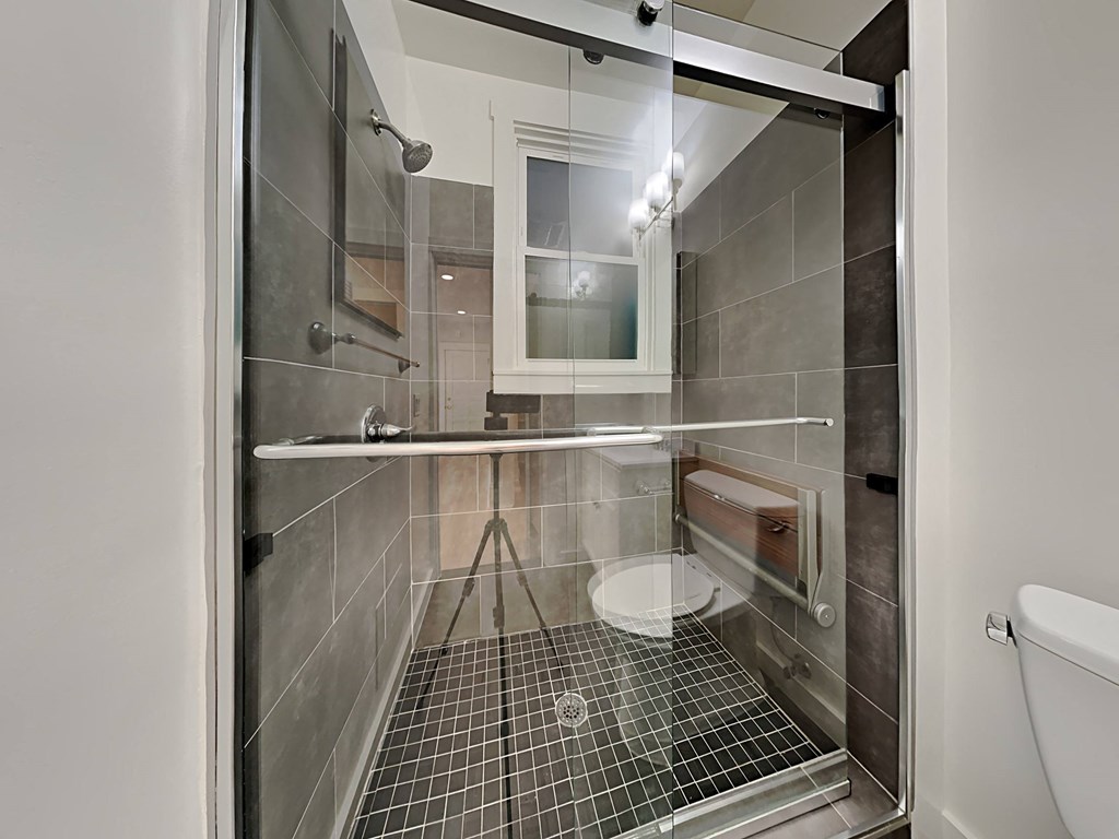 a bathroom with a shower and a sink and a toilet