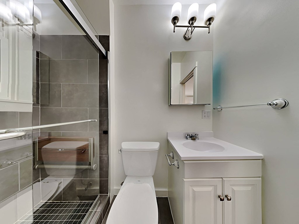 a white bathroom with a shower toilet and sink