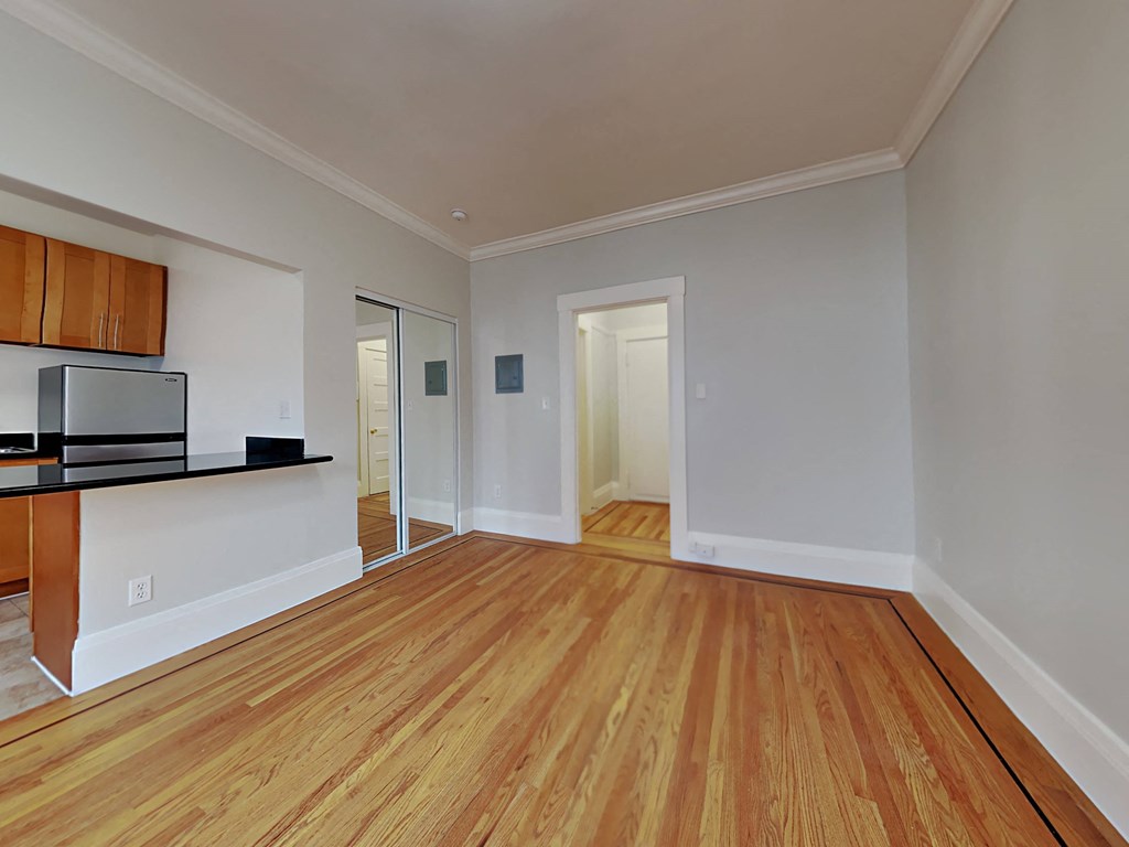 a living room with a hard wood floor and a kitchen